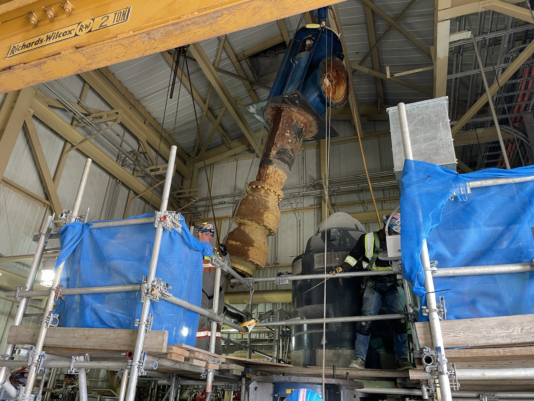 A suspended vertical pump assembly with personnel and access platforms